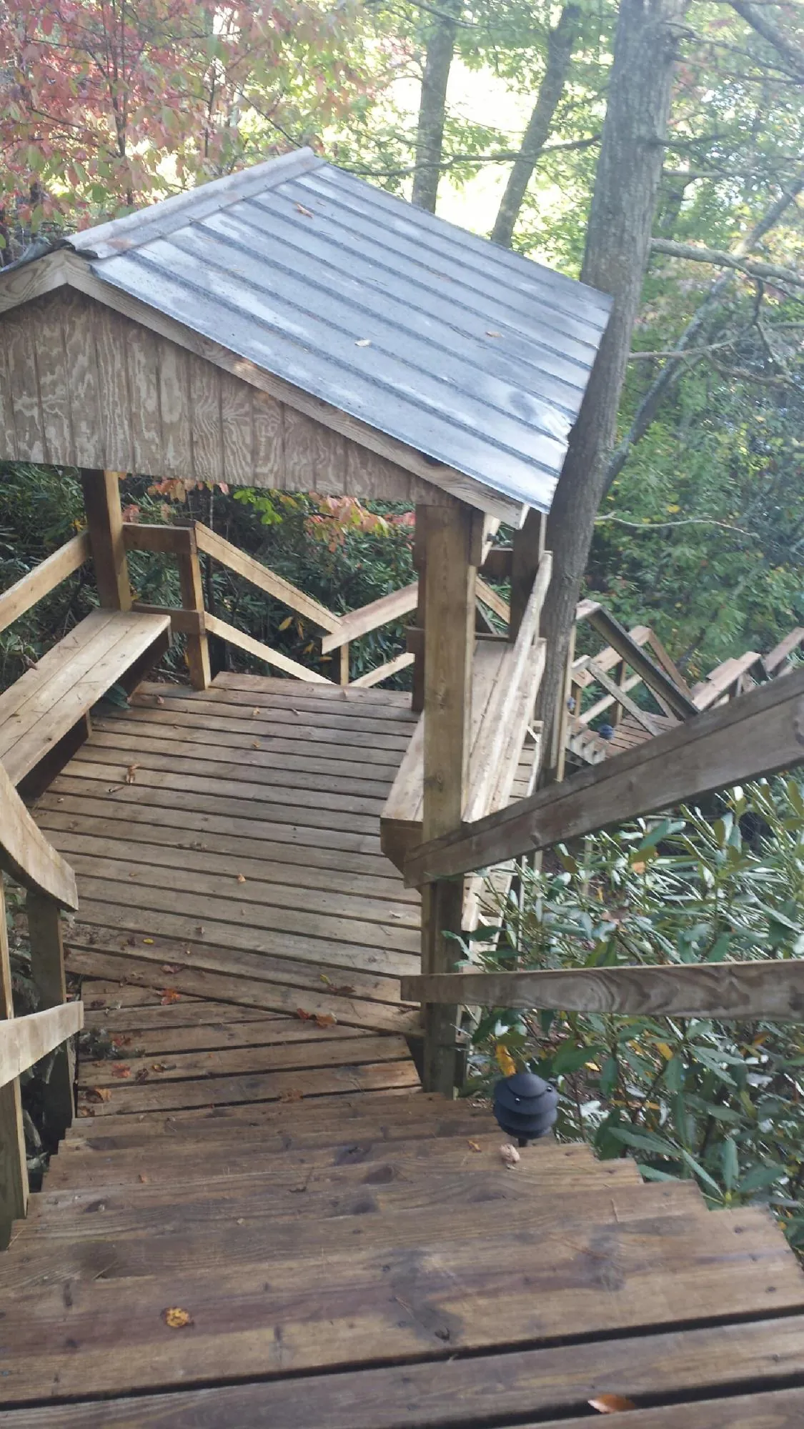 Metal roofed shelter over wooden steps on a wooded walkway — Skylight Repair & Installation work by our crew in Payson